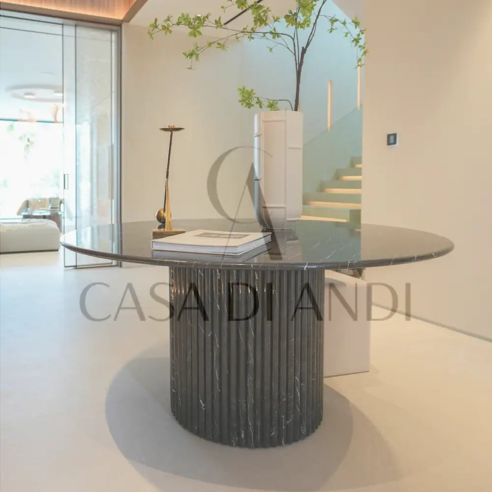 A luxurious round dining table made of black marquina marble with fluted leg design made in Dubai.