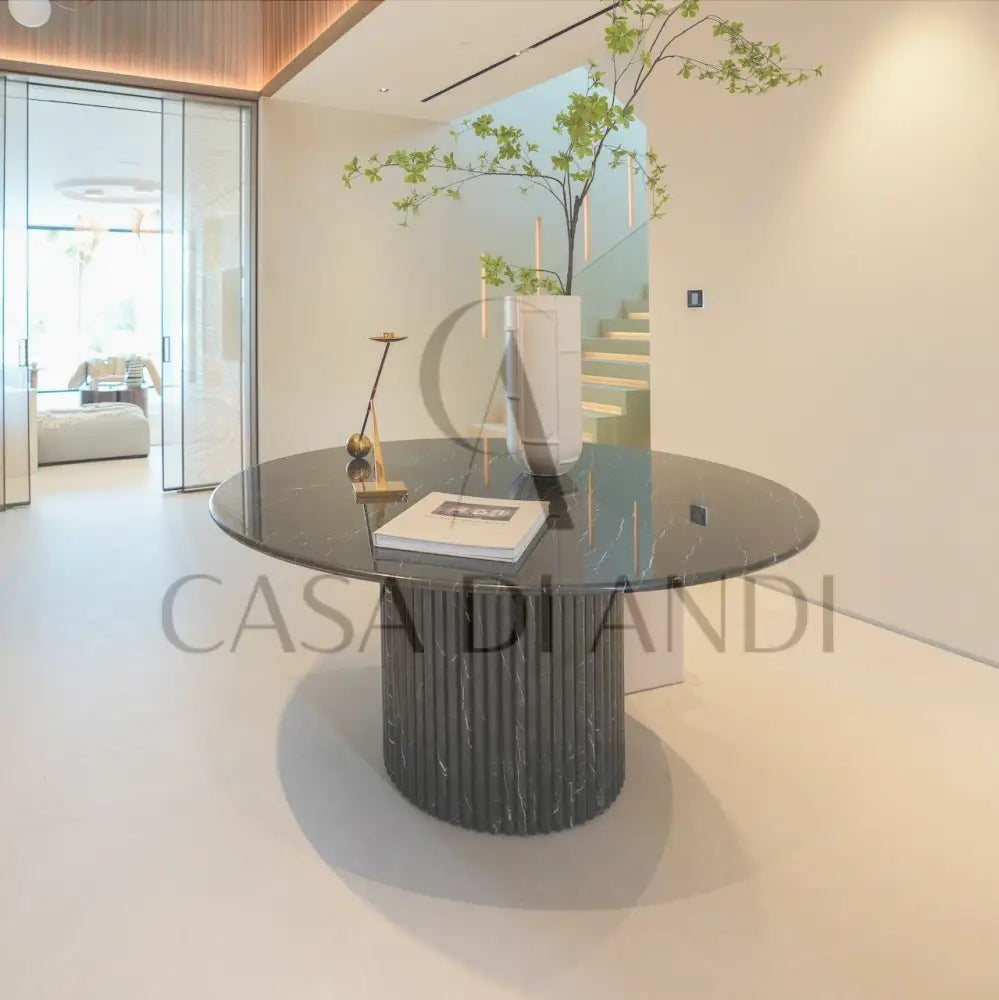 A luxurious round dining table made of black marquina marble with fluted leg design made in Dubai.