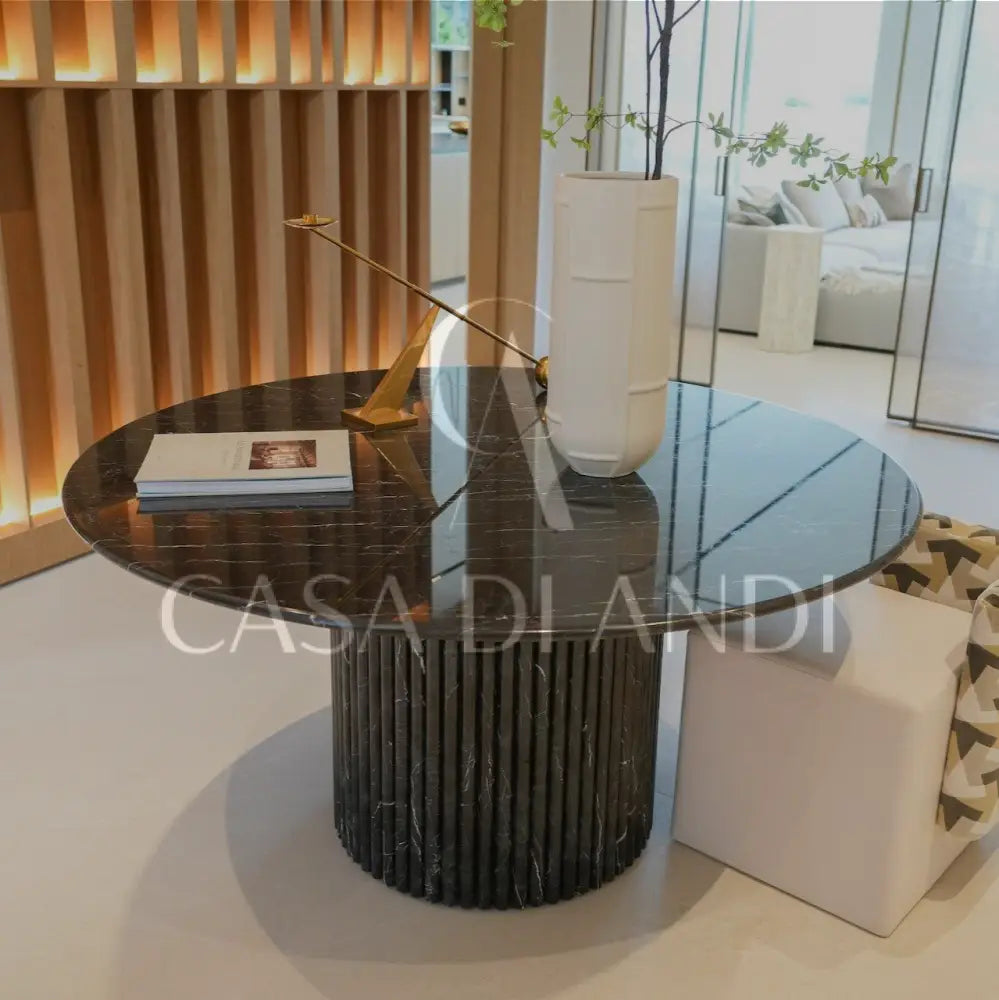 A luxurious round dining table made of black marquina marble with fluted leg design made in Dubai.
