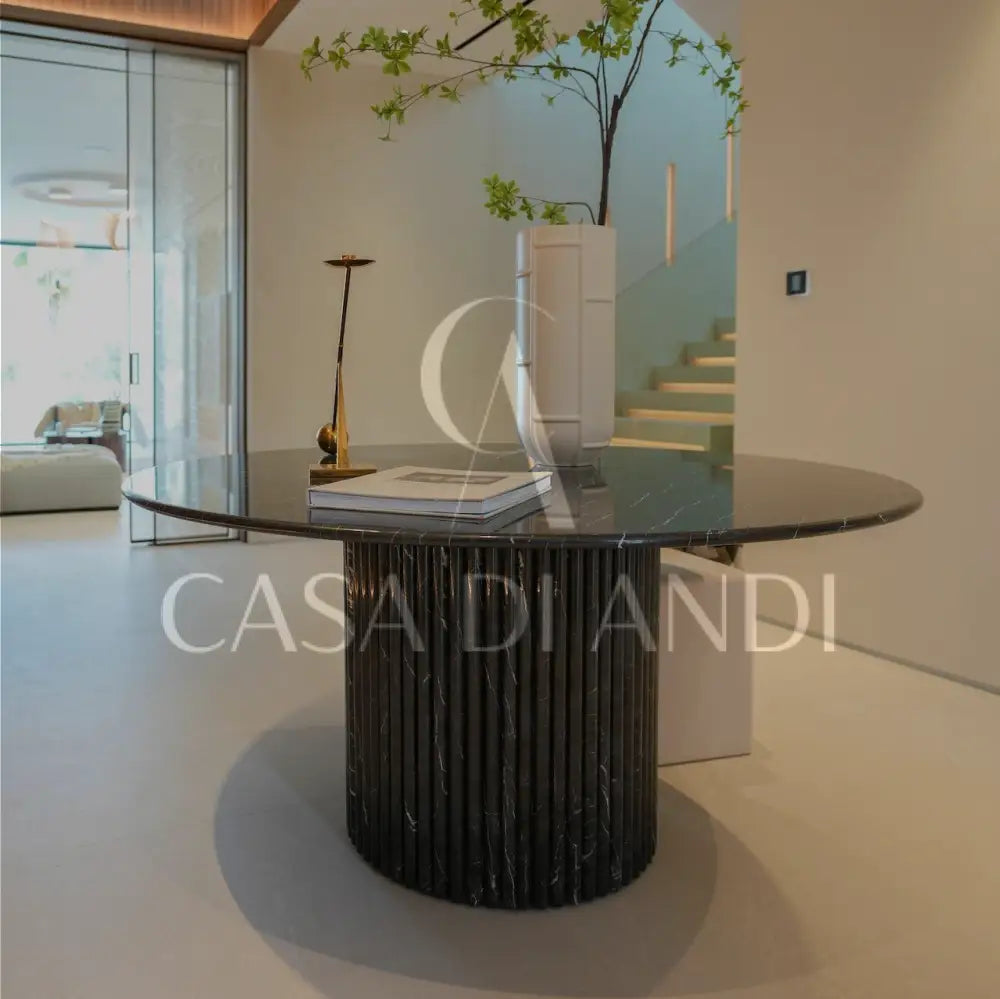A luxurious round dining table made of black marquina marble with fluted leg design made in Dubai.