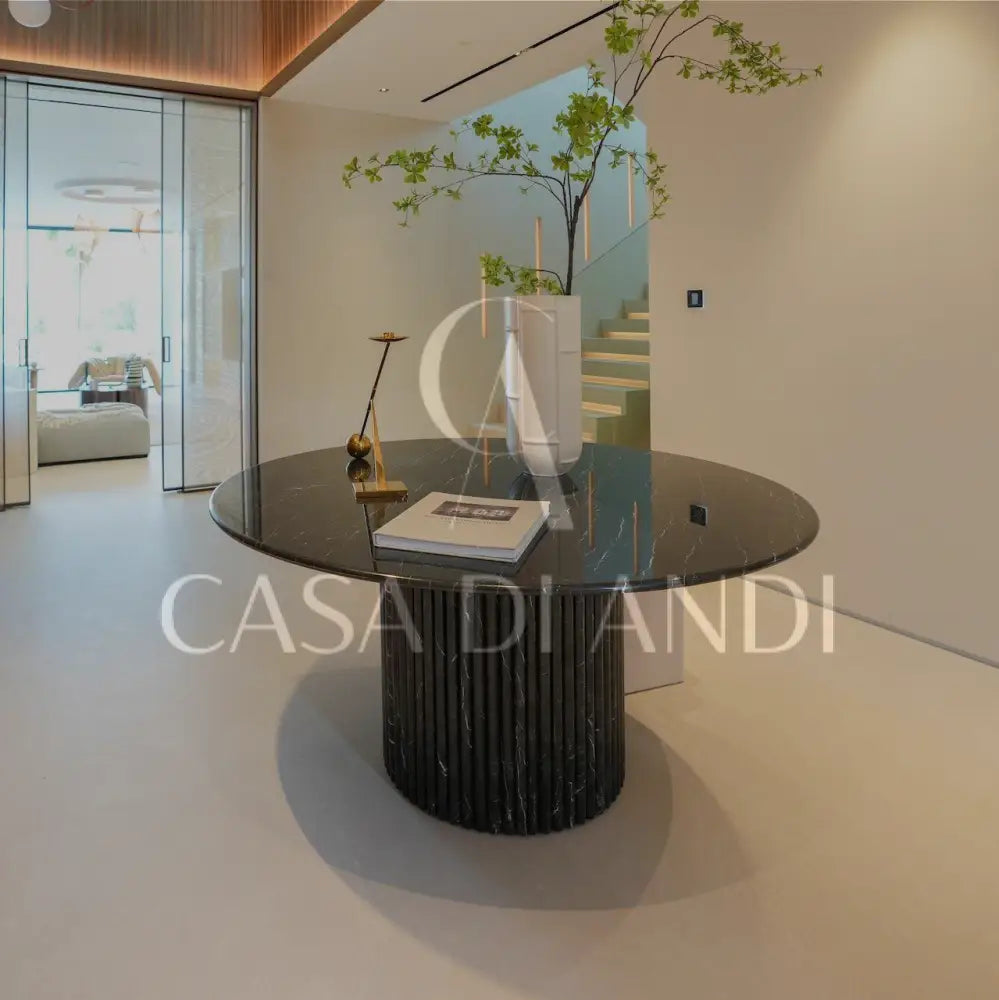 A luxurious round dining table made of black marquina marble with fluted leg design made in Dubai.