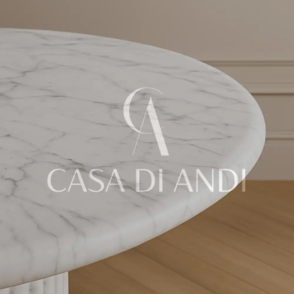 A luxurious round dining table made of Carrara white marble with fluted leg design made in Dubai.