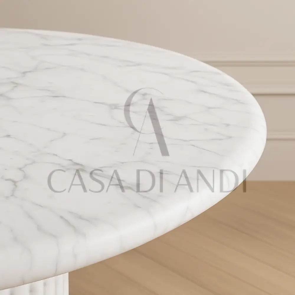 A luxurious round dining table made of Carrara white marble with fluted leg design made in Dubai.