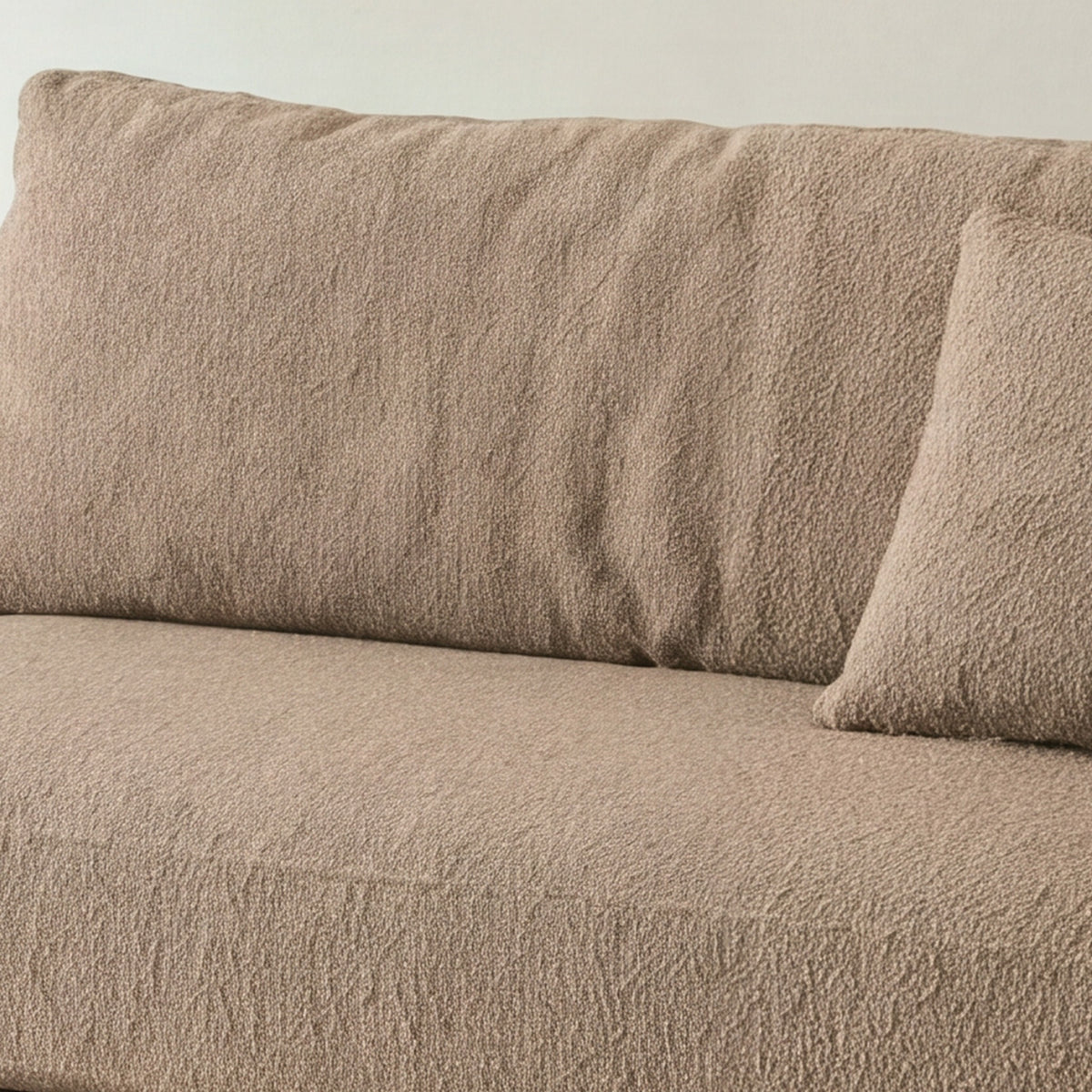 Close-up of the beige bouclé seat cushion on the Cornice sofa