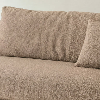 Close-up of the beige bouclé seat cushion on the Cornice sofa