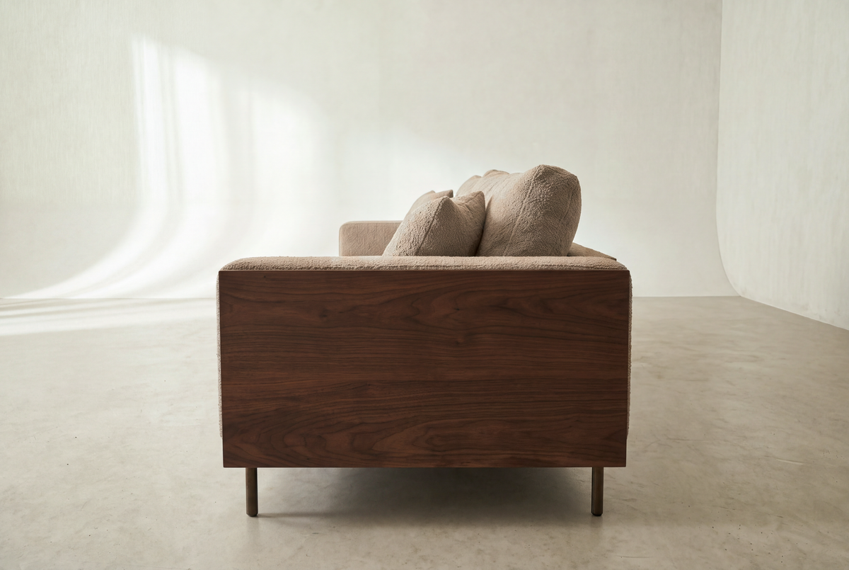 Cornice sofa side view showing the walnut-finish arm panel and bronze legs