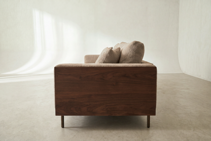 Cornice sofa side view showing the walnut-finish arm panel and bronze legs