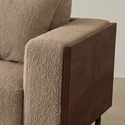 Close-up of the Cornice walnut-finish arm corner and bouclé cushion