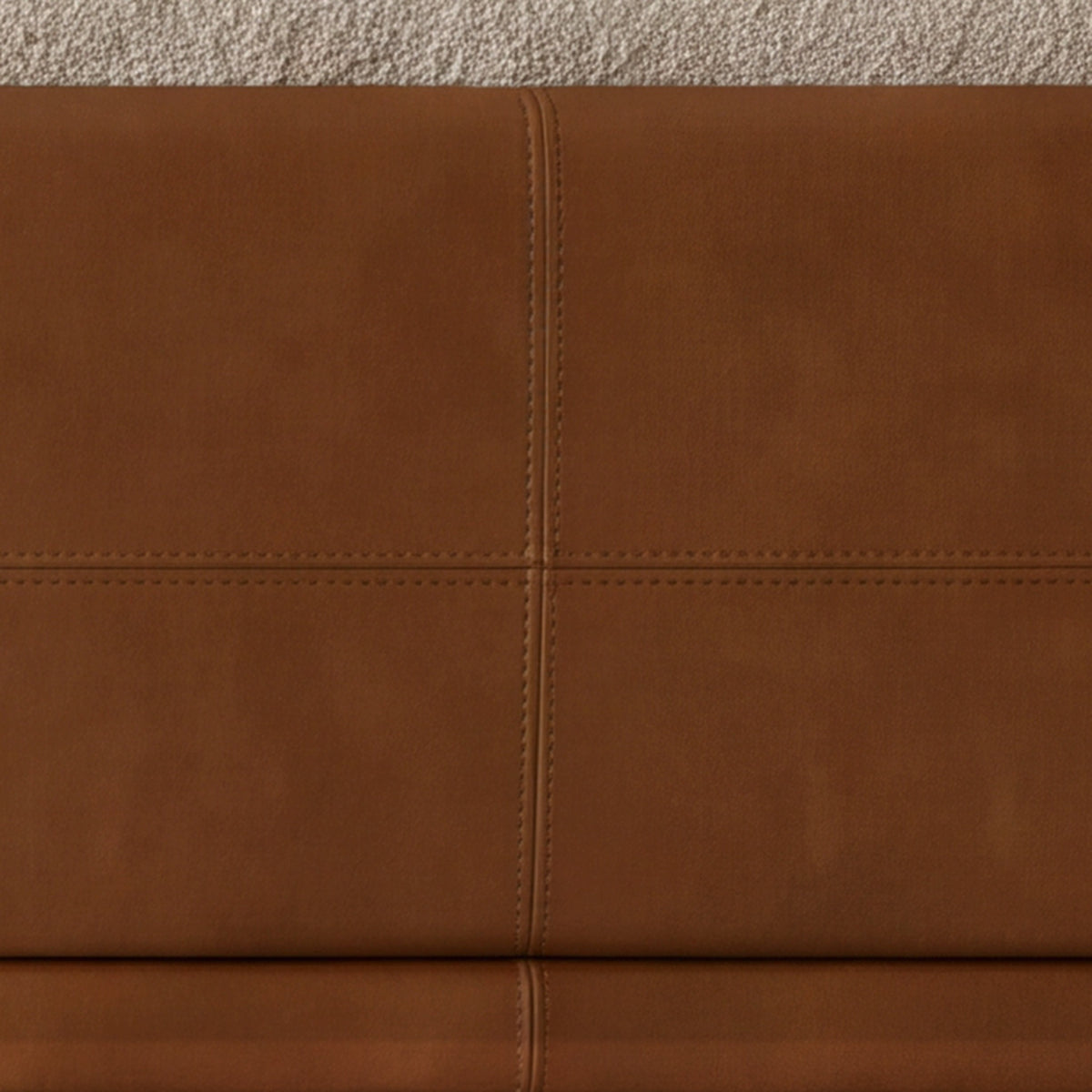 Close-up of the stitched cognac leather frame on the Sella sofa
