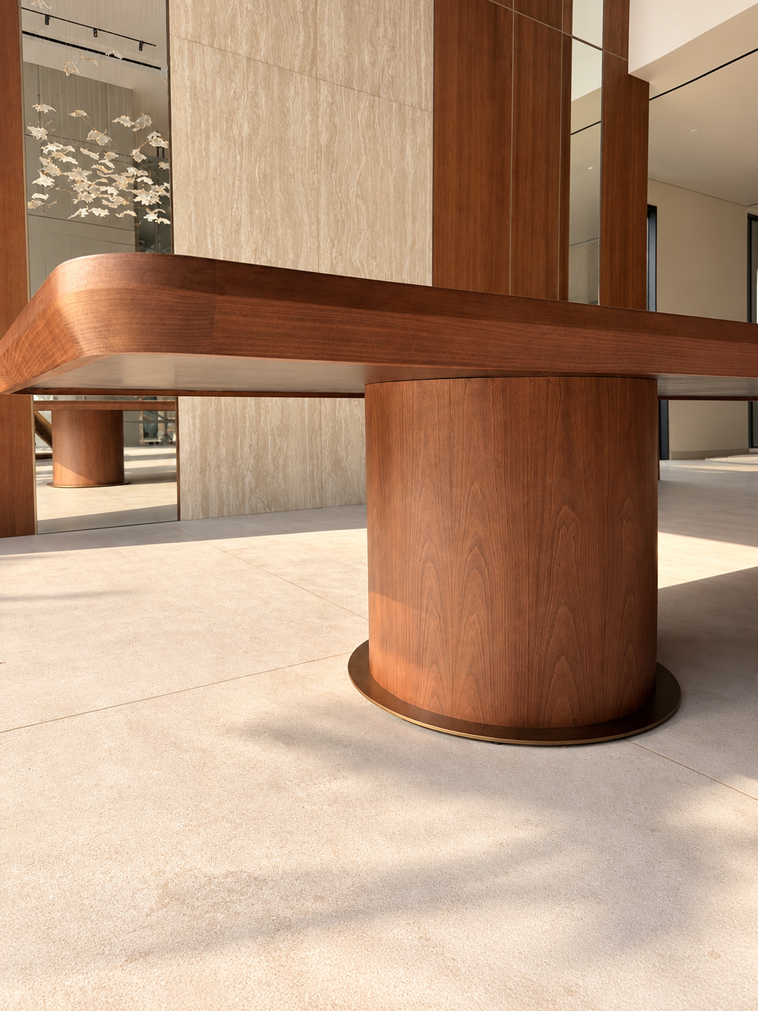Close-up of a walnut pedestal base and curved walnut table edge