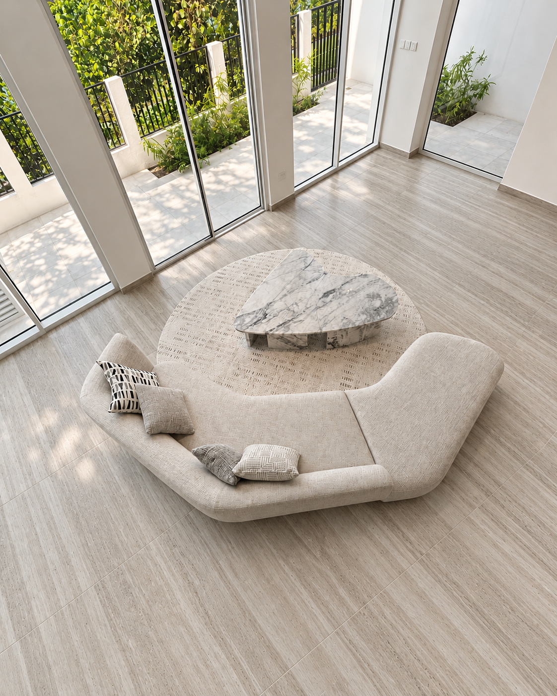 Custom curved cream sofa with a sculptural marble coffee table on a round rug, seen from above
