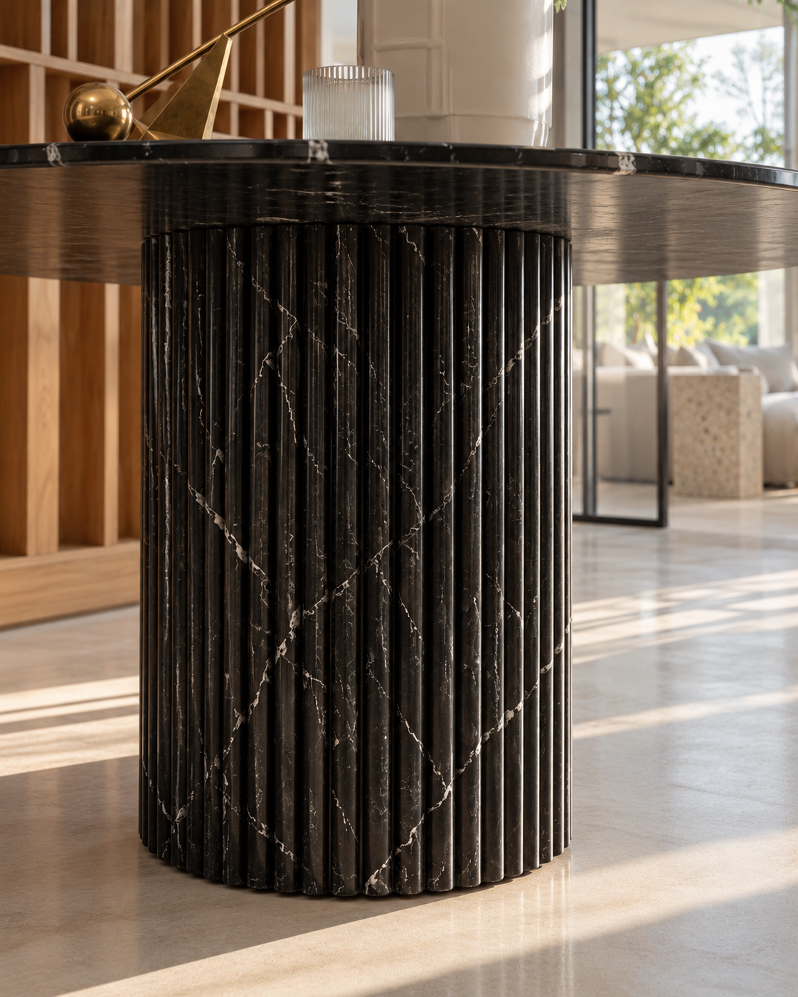 Close-up of the fluted Black Marquina marble base of the Dominio round dining table in warm daylight
