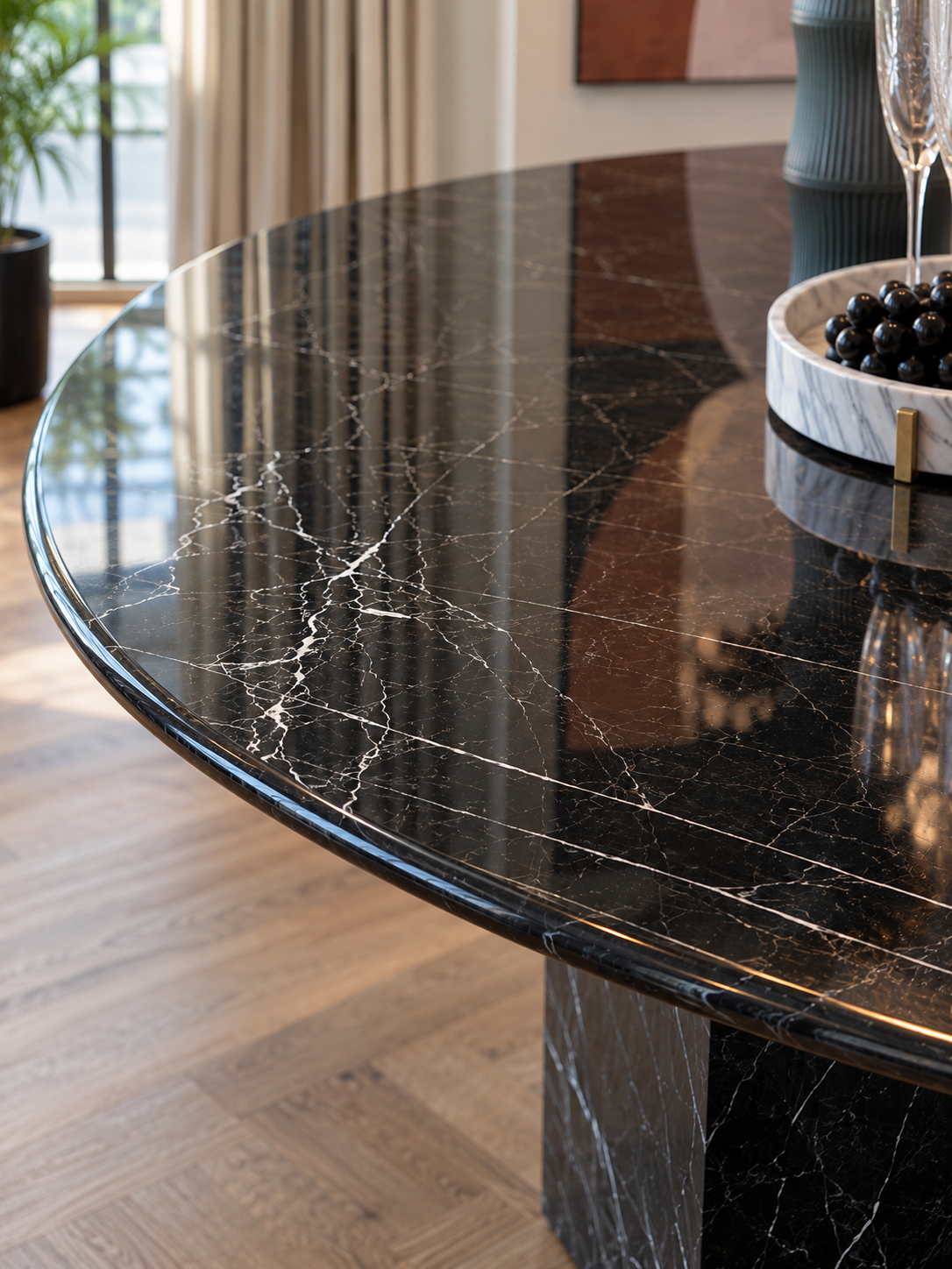Close-up of polished Black Marquina marble round tabletop with natural white veining and rounded edge