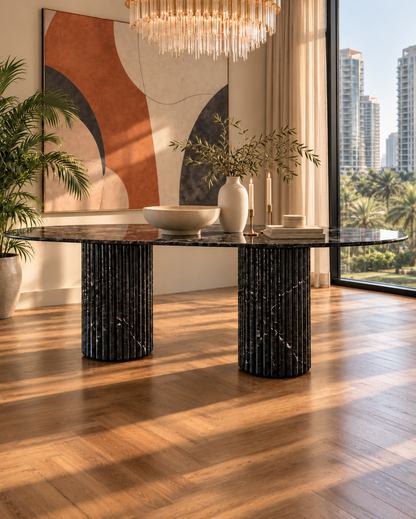 Impero oval dining table in Black Marquina marble on twin fluted marble columns, in a sunlit dining room with a city view