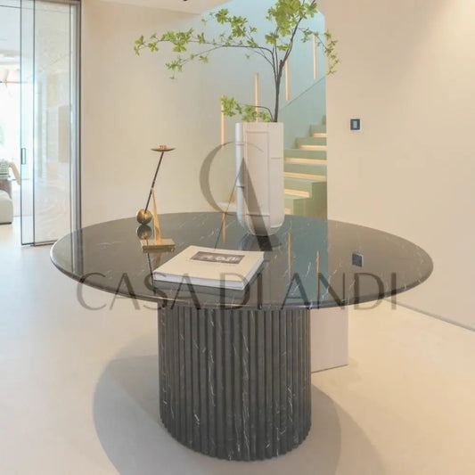 A luxurious round dining table made of black marquina marble with fluted leg design made in Dubai.
