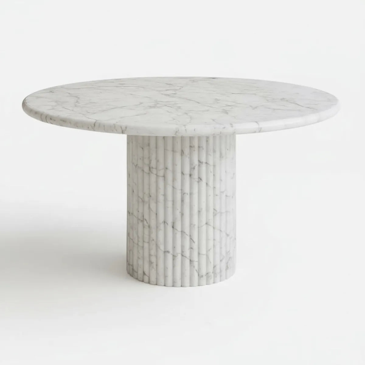 Round marble dining table with a fluted cylindrical base on a white background