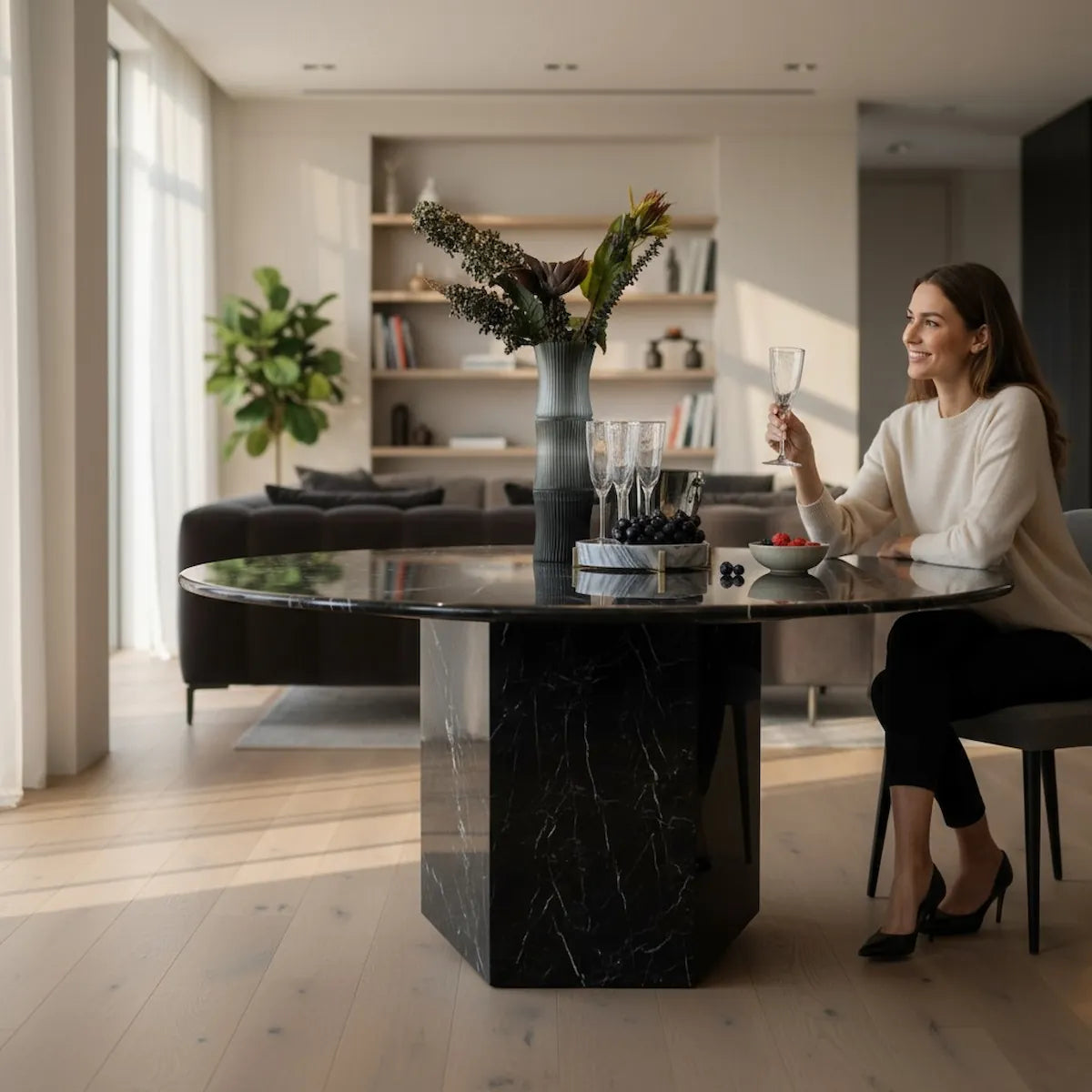 Black marble dining table with a vase of flowers and glasses on a white background