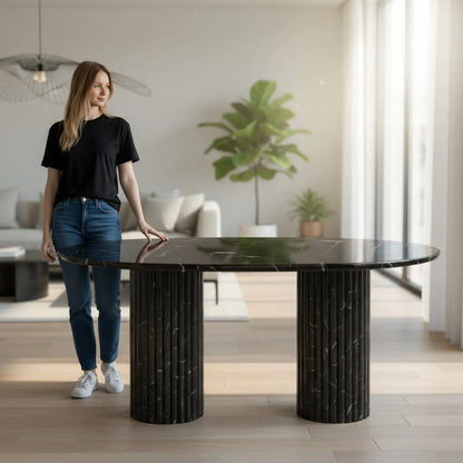 Woman standing next to a black marble dining table in a modern living room in Dubai